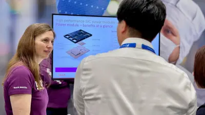 A Bosch expert informs a trade fair visitor about our SiC power modules