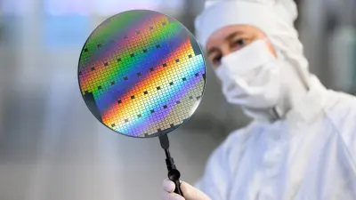 A Bosch employee looking at silicon carbide chips on a wafer