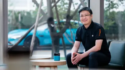 Zhenyu Huang with the Xiaomi SU7 in the background.